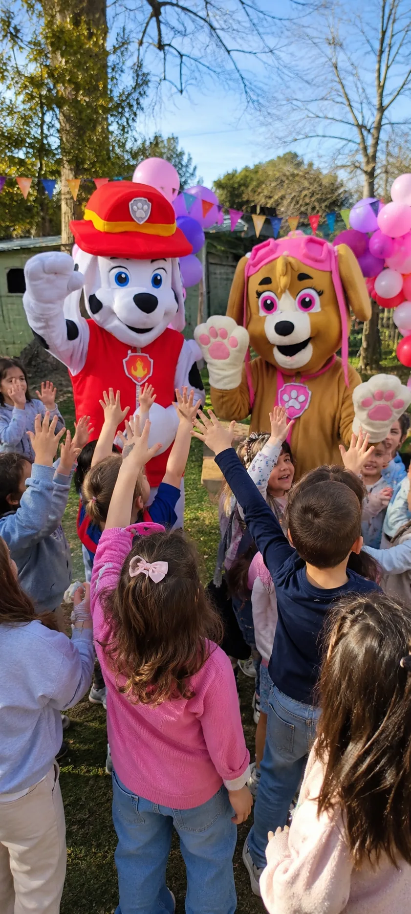 Marshall y Skye de Patrulla Canina saludando a un grupo de niños